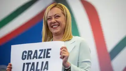 Giorgia Meloni, Vorsitzende der rechtsradikalen Partei Fratelli d'Italia, hält ein Schild mit der Aufschrift «Grazie Italia» («Danke Italien») in die kameras.