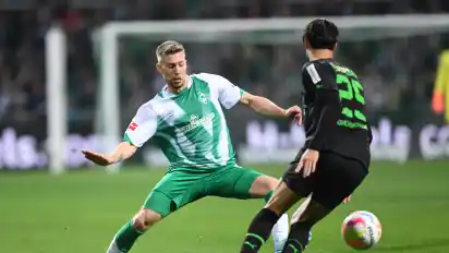 Gladbachs Ramy Bensebaini (r) kämpft gegen Werders Mitchell Weiser um den Ball.