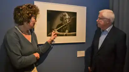 Kuratorin Karin Walter und Harald Kühn vom Heimatverein Lilienthal bei einem Rundgang durch die Ausstellung. An der Wand hängt ein Bild, das Barbara Frank, Tochter von Julius Frank, als Kind zeigt.