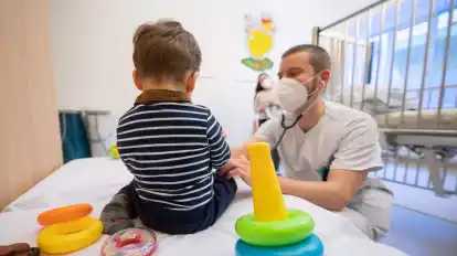 Ein Arzt untersucht in einer Kinderklinik ein Kind.