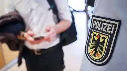 Ein Beamter der Bundespolizei kontrolliert einen Mann.