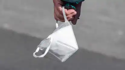 Ein Passant trägt eine FFP2-Maske in der Hand.