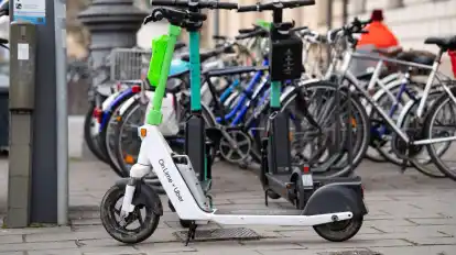 E-Scooter stehen in der Innenstadt von München auf einem Gehweg.
