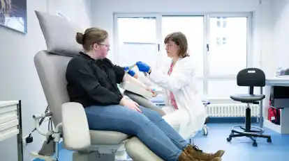 Katharina Egger-Heidrich (r), Fachärztin Onkologie, bereitet die Patientin Michelle Müller im Nationalen Centrum für Tumorerkrankungen am Universitätsklinikum auf eine Blutabnahme vor.