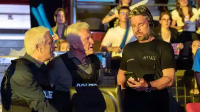 Franz Leitmayr (Udo Wachtveitl, l-r) und Ivo Batic (Miroslav Nemec) zeigen Referee (Danny Rosness) ein Foto.