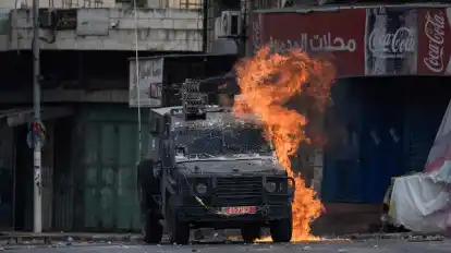 Ein von einem palästinensischen Demonstranten geworfener Molotowcocktail explodiert auf einem israelischen gepanzerten Fahrzeug in Nablus.