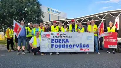Die Streikenden haben sich mit Bannern und Fahnen vor der Einfahrt von Edeka in Dreye eingefunden.