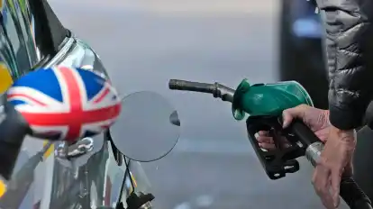 Ein Mann betankt ein Auto an einer Tankstelle in London.