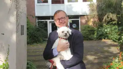 Pastor Stefan Sarod und Hund Emil vor dem Gemeindenzentrum Guter Hirte.