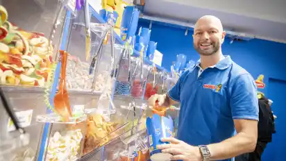 An der Candy-Bar können sich Kunden wie hier Regionalleiter André Behnisch selbst ihre persönliche Nasch-Mischung zusammenstellen.