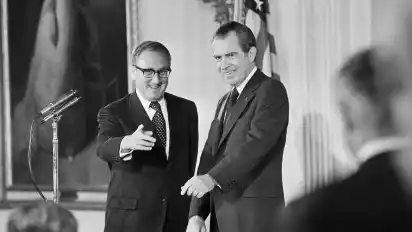 Damaliger Außenminister Henry Kissinger (l) gestikuliert im East Room des Weißen Hauses neben dem damaligen Präsident Richard Nixon.
