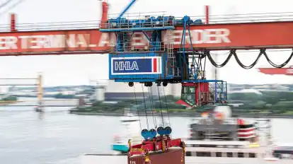 Ein Container wird auf dem Container-Terminal Altenwerder im Hamburger Hafen mit einer Containerbrücke auf ein Schiff geladen.