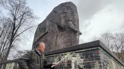 Frank Deitschun, Sachverständiger für Gebäudeschäden, zeigt Ausblühungen im Mauerwerk des erst vor wenigen Jahren sanierten Antikolonialdenkmals.