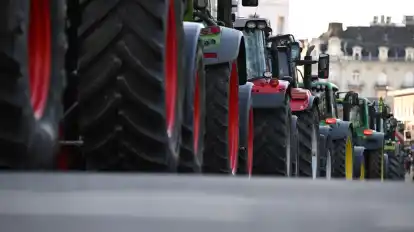 Bauern fahren mit ihren Traktoren während einer Kundgebung auf einer Straße.