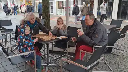 Ursula und Walter Schomburg genießen mit ihren Enkeln Mateo und Talea Pizza in der Vegesacker Fußgängerzone.