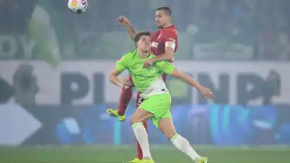 Wolfsburgs Kevin Behrens (l) spielt gegen Stuttgarts Waldemar Anton.
