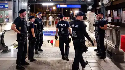 Bundespolizisten stehen am Hauptbahnhof und überprüfen, ob Passanten illegale Waffen mit sich führen.