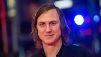 Schauspieler Lars Eidinger steht im Berlinale Palast auf dem Roten Teppich.