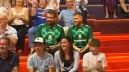 Zwei Mitarbeiter der Medienabteilung des SV Werder Bremen sitzen im Hintergrund des ZDF-Sportstudios.