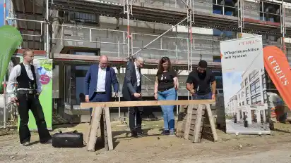 Johannes Knake, Torsten Rode, Stefanie Zacharias-Srocke und Karim Abdel-Rekim schlugen beim Richtfest der Seniorenresidenz Am Hohenberg in Osterholz-Scharmbeck den symbolischen letzten Nagel in einen Dachbalken.