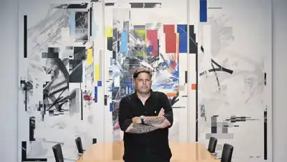 Der Bremer Graffiti-Künstler Markus Genesius vor seinem Werk zum Thema Demokratie und Gewaltenteilung, das in der Bremischen Bürgerschaft hängt.
