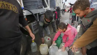 Kinder holen Wasser aus einem Lastwagen in einem Zeltlager für vertriebene Palästinenser in Deir al-Balah im zentralen Gazastreifen.