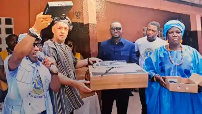 Die Lions-Freunde Eklou Attohoun and Andreas Schaefer (von links) überreichen bei einer feierlichen Zeremonie in Lomé 25 Computer an die Schule La Delivrance.