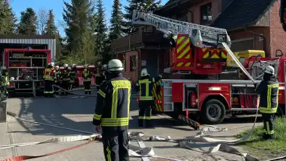 Mit einer Drehleiter machten sich Mitglieder der örtlichen Feuerwehr am Ostersonntag daran, einen Brand in Worphausen zu bekämpfen.