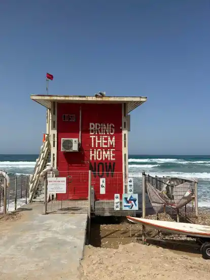 Allgegenwärtig: die Geisel-Parole ”Bring them home now” auf einer Bude am Strand von Haifa.