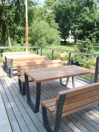Eine Terrasse mit Tischen und Bänken direkt am Fleet lädt zum Genießen ein.