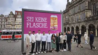 Sei keine Flasche – mehr Herz für Dosenbier! Professor Christoph Burmann (links) zusammen mit Stefan Gräfe vom Hopfenfänger (rechts, Bremer Braumanufaktur) und in der Mitte die Marketing-Studierenden mit dem Plakat, dass sie als Kampagne für den Hopfenfänger entwickelten.