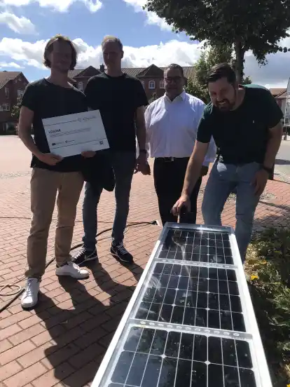 Testen die Solarbank am Kirchweyher Marktplatz (von links): Michael Wischnewski, Carsten Platt, Frank Seidel und Malte Schwander.