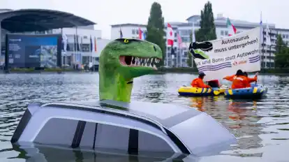 Schon vor der offiziellen Eröffnung protestierte Attac mit einem „Autosaurus“ am Münchner Messegelände.