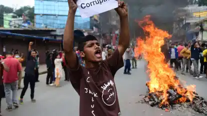 Ein Demonstrant in Nepal hält ein Blatt mit der Forderung nach einem Ende der Korruption hoch.