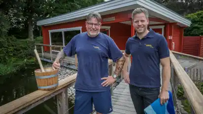 Auf dem Weg zur Teichsauna: Mit Eimer, Schöpfkelle und Handtuch bewaffnet gehen Jörn Kruse (l.) und Arne Lindhorst zum stündlichen Aufguss.