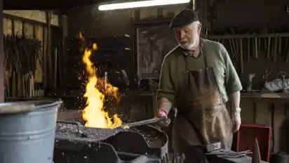 Heinz Heumann arbeitet in der Schmiede an den Beinen eines Tischs.