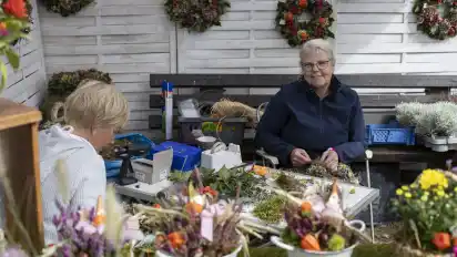 Dörthe Schmidt (links) und Gundula Böttjer binden Blumenkränze.