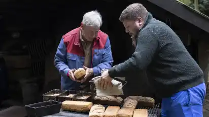Werner Feldmann (links) und Marco Feldmann holen frische Brote aus dem Steinbackofen.